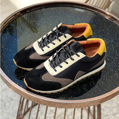Les chaussures durables de sports sportifs glissent non le noir de chaussures en cuir doux de tennis