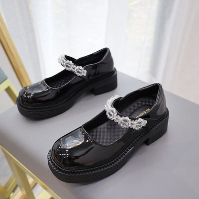 Les enfants allument des chaussures de sport, de nouveau au noir de chaussures en cuir confortable de filles d'école