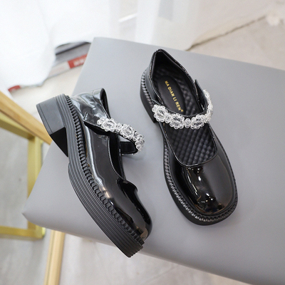 Les enfants allument des chaussures de sport, de nouveau au noir de chaussures en cuir confortable de filles d'école
